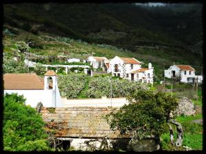 a group of houses on a hill with trees at Casa Rural Amasín in Valverde