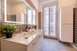 ニースにあるGuest House Chez Bastienの洗面台と大きな鏡のあるバスルーム