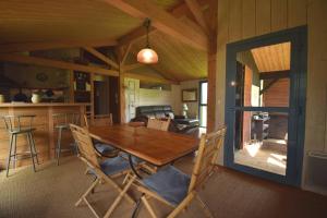 a dining room and kitchen with a wooden table and chairs at Le Séchoir Aquitain, logement insolite in Dolmayrac
