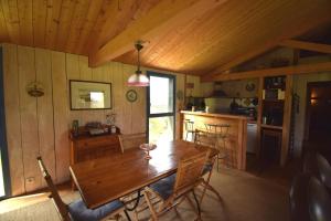 a dining room with a wooden table and a kitchen at Le Séchoir Aquitain, logement insolite in Dolmayrac +14 photos