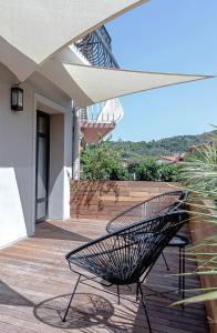 a bench sitting on a wooden deck with a building at Les Suites de Collioure in Collioure
