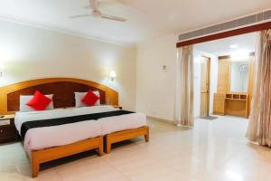 een slaapkamer met een groot bed met rode kussens bij Kings Snow Palace in Tirunelveli