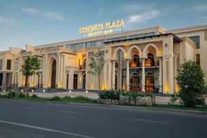 a large white building with a sign on top of it at Kohinur Plaza in Samarkand