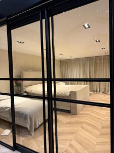 a bedroom with a bed and a glass wall at Luxury Apartment near Amsterdam in Purmerland