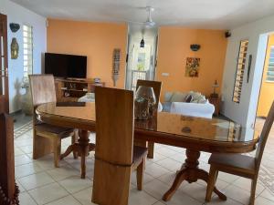 a living room with a wooden table and chairs at Belle villa avec piscine à Caféière in Radelin