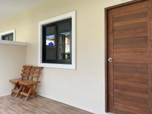 a wooden door and a wooden chair in a room at Apartement 28 Stay High in Thongsala
