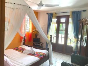 a bedroom with a bed with a canopy at Belle villa avec piscine à Caféière in Radelin