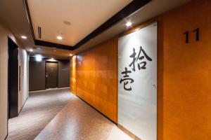 a hallway with a wall with chinese writing on it at HOTEL MYSTAYS PREMIER Kanazawa in Kanazawa
