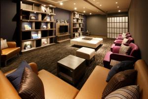a waiting room with couches and chairs and a tv at HOTEL MYSTAYS PREMIER Kanazawa in Kanazawa