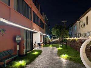 a walkway with lights next to a building at night at Shanghai Guiwu Village Near Disney Resort in Shanghai