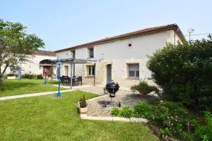una griglia in un cortile accanto a un edificio di Gîte l'Ostalet de Sarron à Brax, Lot et Garonne a Brax
