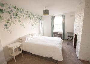 a bedroom with a white bed and a fireplace at The Loft Winchester in Winchester