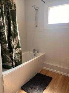 a bathroom with a tub and a shower curtain at Évasion in Marmande