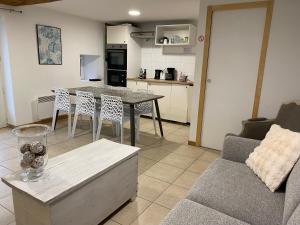 a kitchen and living room with a table and a couch at Les rives du Lay gîte Charette in Le Boupère