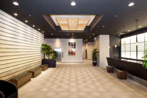 a lobby with a waiting room with potted plants at HOTEL MYSTAYS PREMIER Kanazawa in Kanazawa