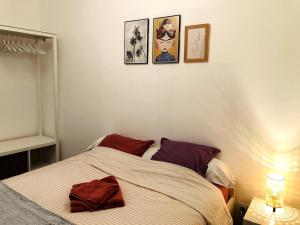 a bedroom with a bed with three pictures on the wall at Charmant appartement coeur de centre ville in Sablé-sur-Sarthe