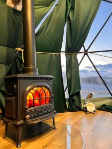 a stove in a tent with a cat laying on the floor at Glamping Sfera Marzeń in Szewna