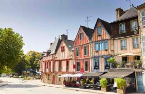 a group of buildings with tables and chairs in a street at Belle maison entre les sentiers côtiers et la vieille ville in Vannes