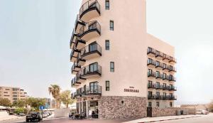 a tall building with balconies on the side of it at Hotel Shoshana - Adults Only in Eilat