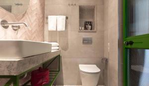 a bathroom with a white sink and a toilet at Hotel Shoshana - Adults Only in Eilat