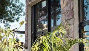 a window on a brick building with a sign in it at Hotel Shoshana - Adults Only in Eilat