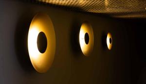 two lights on a wall with eyes on it at Hotel Shoshana - Adults Only in Eilat
