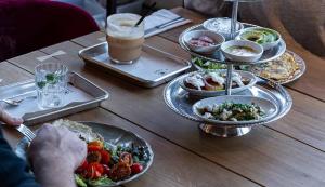 a table topped with plates of food and a drink at Hotel Shoshana - Adults Only in Eilat