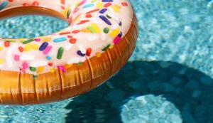 a frosted donut with sprinkles on top of a pool at Hotel Shoshana - Adults Only in Eilat