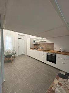 Una cocina con gabinetes blancos y una mesa y una silla. en Corsico Comfort Loft - Affitti Brevi Italia, en Corsico