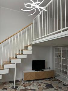 sala de estar con TV bajo una escalera en Corsico Comfort Loft - Affitti Brevi Italia, en Corsico