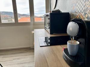 a coffee machine sitting on a counter next to a microwave at Belle vue à 500m des thermes - climatisé in Royat