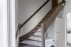 a staircase in a house with a washing machine at Nieuwlanderweg 51 in De Waal +8 photos