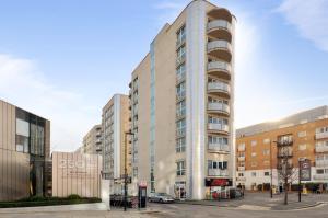 un edificio alto en una calle de la ciudad con edificios en Access Apartments City, en Londres