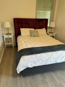 a bed in a bedroom with two nightstands and two lamps at Hotel Koorawatha garden unit - ground floor in Koorawatha