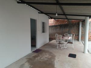 a patio with a table and chairs and a brick wall at Casa de Hospedagem São João in Barra do Garças