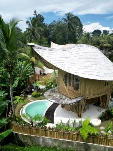 a building with a swimming pool in front of a resort at JinengBali Eco Lodge in Tegalalang