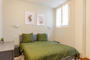 1 dormitorio con cama verde y escritorio en Lake And Mountain Comfort Flat, en Lecco
