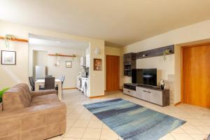 Una sala de estar con un sofá y un televisor de pantalla plana. en Lake And Mountain Comfort Flat, en Lecco