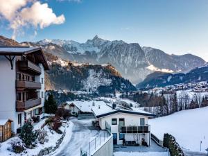 a snow covered village with mountains in the background at Apartment Bichleregg by Interhome in Sautens
