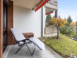a chair sitting on the porch of a house at Studio Krokus Apt-T by Interhome in Wengen +26 photos