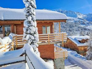 a log cabin in the snow with a tree at Holiday Home Midat soleil by Interhome in Verbier