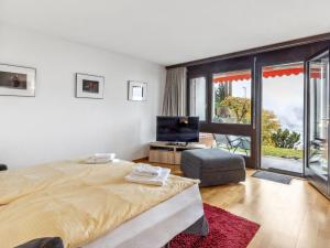 a bedroom with a large bed and a large window at Studio Krokus Apt-T by Interhome in Wengen