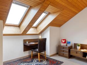 Una habitación abuhardillada con un escritorio y dos tragaluces. en Apartment Eiger Residence Apt-A-425 by Interhome, en Wengen