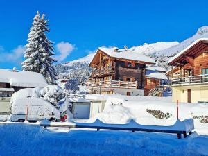 a snow covered yard with a house in the background at Apartment Fury rez by Interhome in Verbier +26 photos