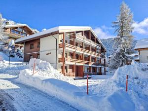 a building covered in snow with a pile of snow at Apartment Lichen 4 by Interhome in Verbier
