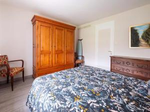 a bedroom with a bed and a wooden cabinet at gite de la croix in Saint-Léon-sur-Vézère