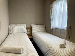 Katil atau katil-katil dalam bilik di Modern 3 Bedroom Caravan, South Cerney