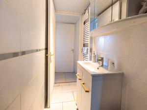 a white bathroom with a sink and a door at gite de la croix in Saint-Léon-sur-Vézère +10 photos