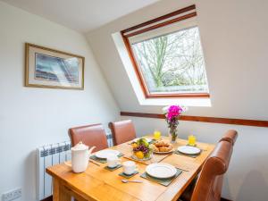 a dining room with a wooden table and a window at Chalet Lothlorien Lodge 4 by Interhome in Spean Bridge