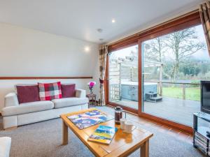 a living room with a couch and a table at Chalet Lothlorien Lodge 4 by Interhome in Spean Bridge